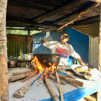 Local resident preparing traditional Dominican dishes on a wood fire as part of the cultural stop of the buggy excursion