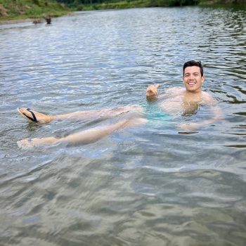 Man floating in the clear waters of the Chavón River, enjoying a peaceful moment during the buggy tour