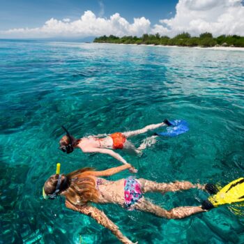 Two travelers snorkeling in the crystal-clear waters of Catalina Island, exploring coral reefs during the Quetzal Excursions tour