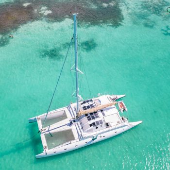 Drone shot of the Quetzal catamaran anchored in shallow turquoise water