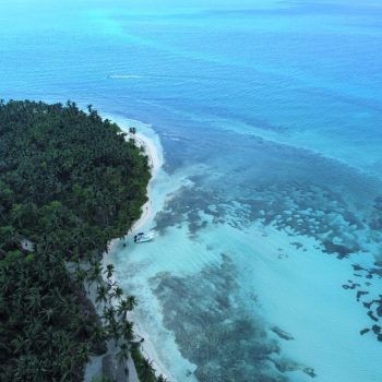 Drone shot showing turquoise reef waters and white sand beach near Saona Island in the Dominican Republic