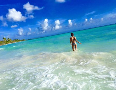 Woman walking in shallow turquoise water during a Saona Island boat tour